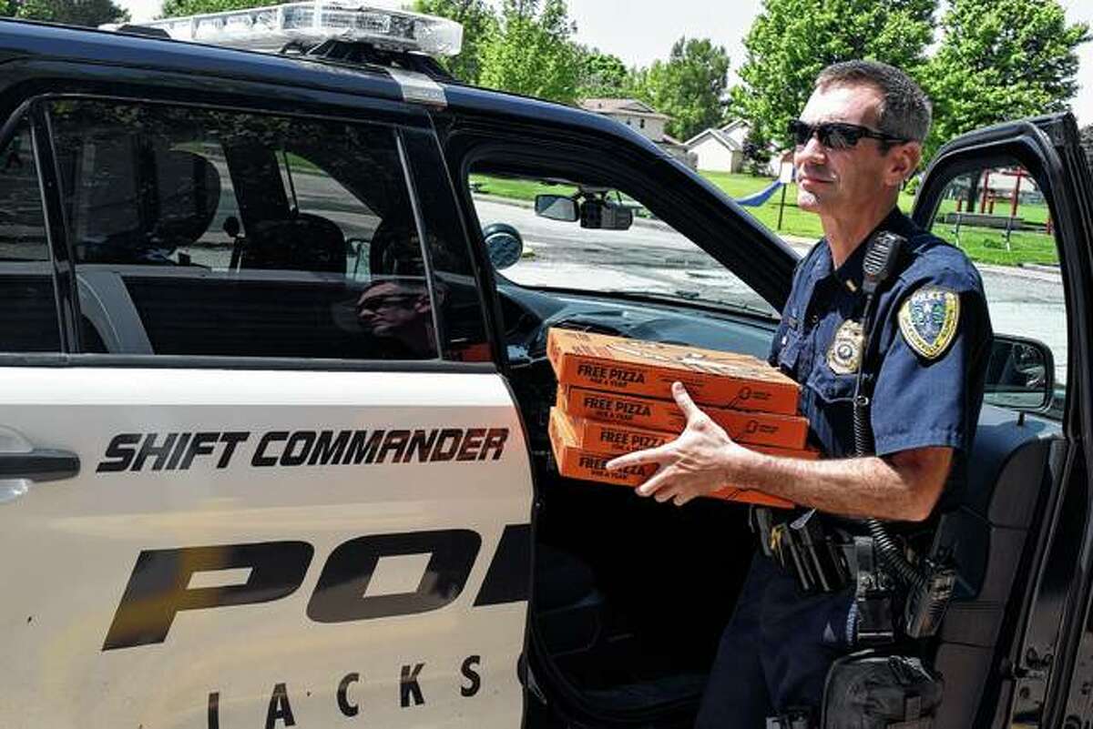Jacksonville Police Lt. Sean Walker delivers pizza Wednesday to Shanon Keller’s fifth-grade class at Eisenhower Elementary School’s after fifth-grader Emalee Pool won first place in the National Police Week Citywide Fifth-Grade Essay Contest.