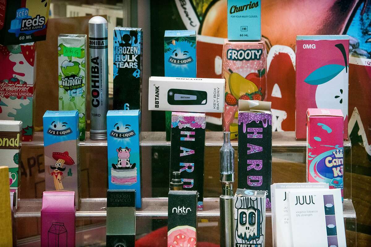 Flavored e-cigarette and vape products on display for sale at a store in New York, Nov. 14, 2018. Stopping short of its threatened ban on flavored e-cigarettes, the Food and Drug Administration said on Nov. 15 that it would allow stores to continue selling the products, but only from closed-off areas that are inaccessible to minors. At the same time, the agency moved to outlaw two traditional tobacco products that disproportionately harm African Americans: menthol cigarettes and flavored cigars. (Joshua Bright/The New York Times)