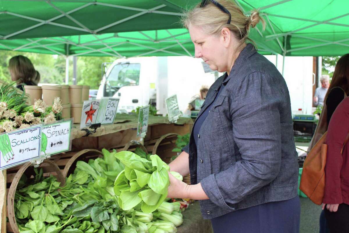 Darien resident Joanne Moore shops for bok choy at the Fort Hills Farm stall at the Westport Farmers Market on May 23, 2019. Moore says she goes to the market every year and tries to lead a healthy lifestyle.