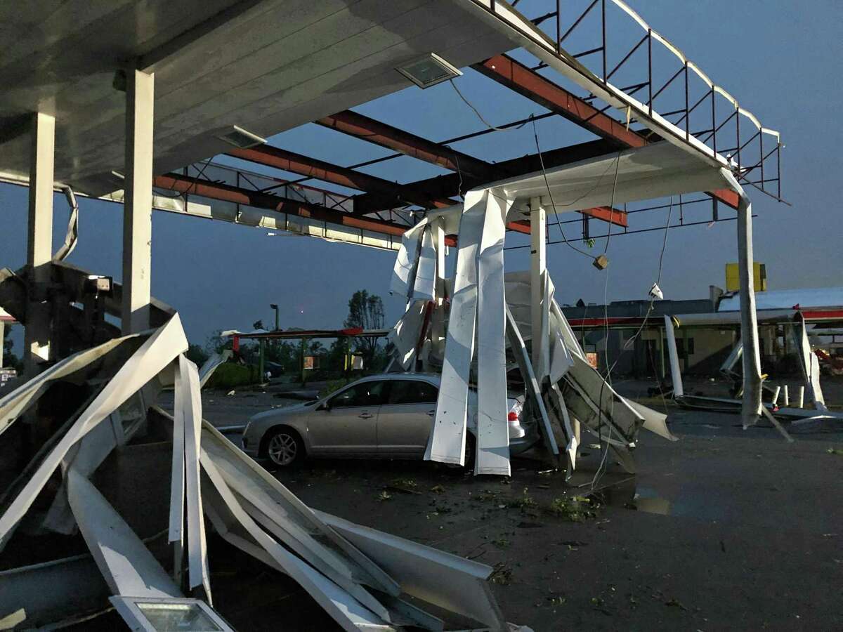 Un auto queda atrapado bajo los restos de un techo de una gasolinera en Jefferson City, Missouri, tras el paso de un tornado, el jueves 23 de mayo de 2019.