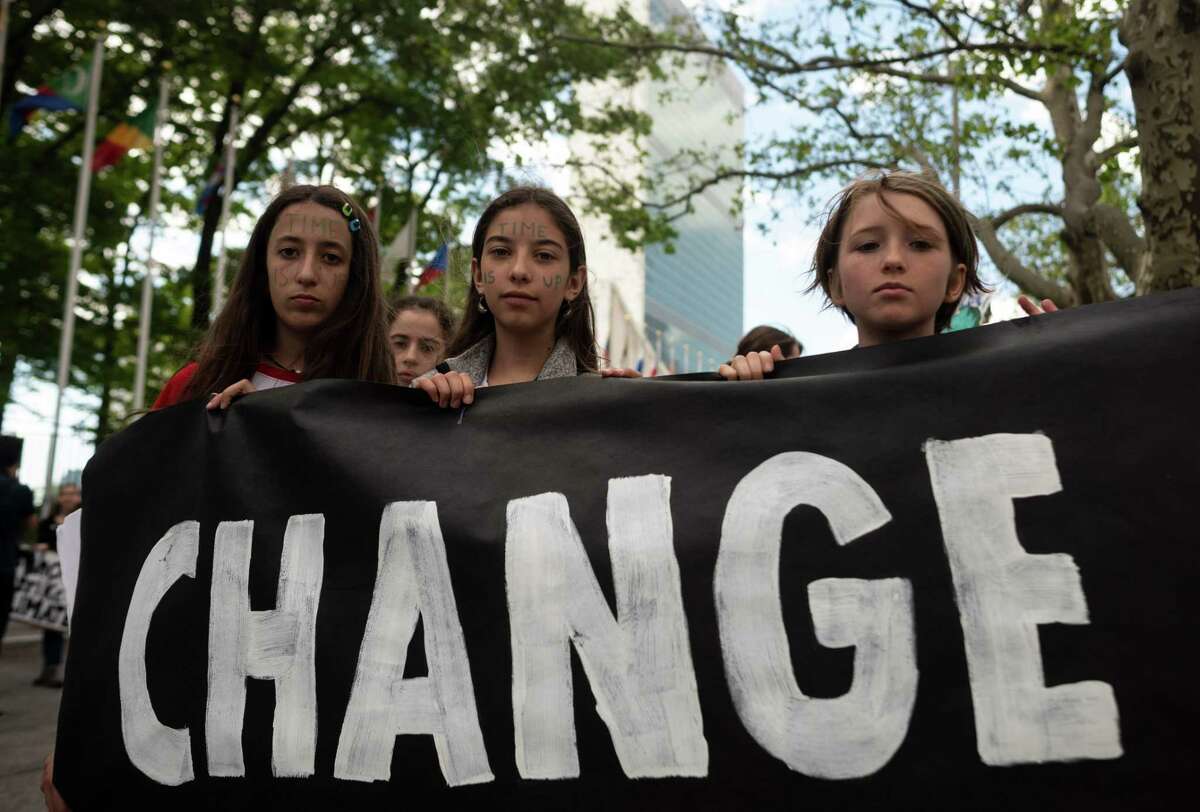 School children hold a placard reading "CHANGE" during the Youth Climate Strike May 24, 2019 outside United Nations headquarters in New York City.