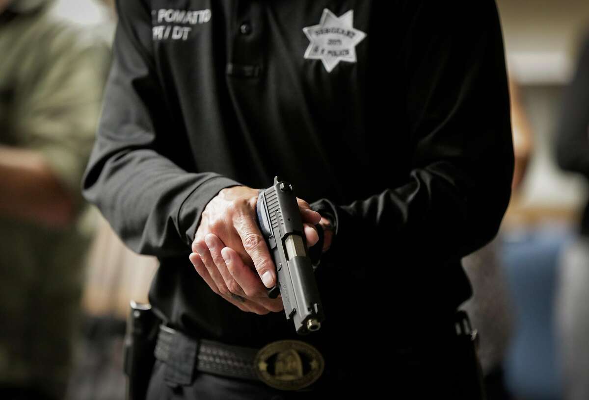Sgt. Steven Pomatto (left) holds a gun while simulating a scenario during a demonstration to the media on how police officers are trained to use force in San Francisco, Calif., on Monday, Sept. 11, 2017. Major law enforcement lobbying groups have dropped their opposition to a bill in Sacramento setting new use of force standards for police.
