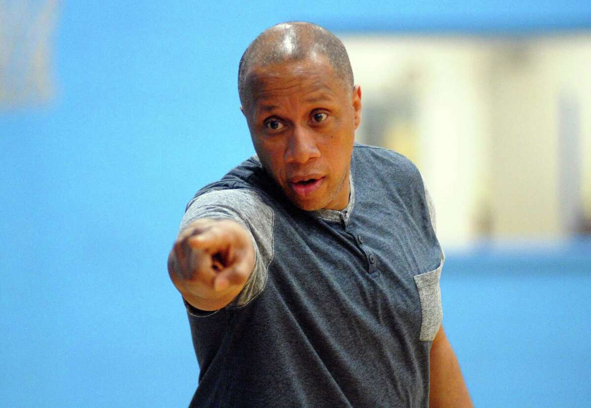 Blue team Head Coach, Bridgeport Police's Capt. Roderick Porter, calls a player off the bench to enter the game during the 2nd Annual Cops Vs Kids basketball game action at the Ralphola Taylor Community Center in Bridgeport, Conn., on Friday Apr. 27, 2018. The game, organized by Community Hands in Action Mentoring Program (C.H.A.M.P.), is intended to be a way for police to connect with city youth and establish a relationship.