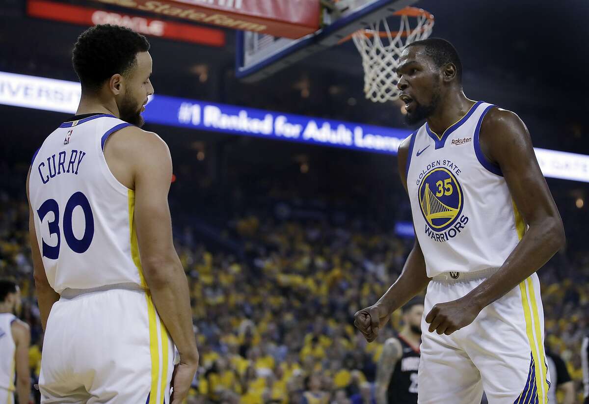 Golden State Warriors' Kevin Durant, right, speaks with Stephen Curry (30) after Curry was called for a foul during the first half of Game 5 of the team's second-round NBA basketball playoff series against the Houston Rockets on Wednesday, May 8, 2019, in Oakland, Calif. (AP Photo/Ben Margot)