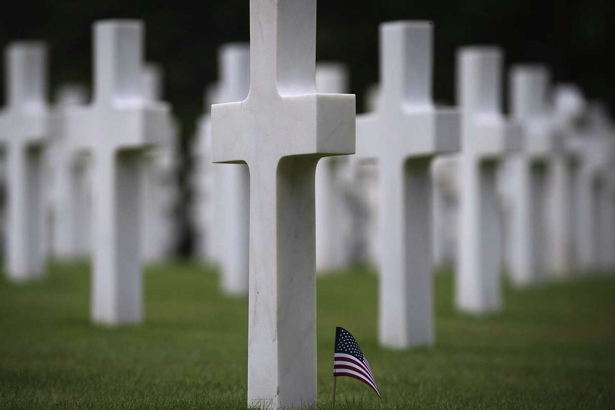 This file photo taken on June 2, 2014, shows a small US flag set up on graves at the US cemetery in Colleville-sur-Mer, in Normandy, north-western France. - The D-Day ceremonies on June 6, 2019, will mark the 75th anniversary since the launch of 'Operation Overlord', a vast military operation by Allied forces in Normandy, which turned the tide of World War II, eventually leading to the liberation of occupied France and the end of the war against Nazi Germany.