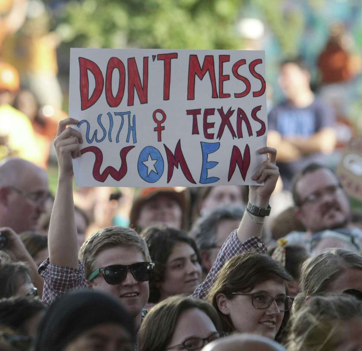 A rally partcipant holds up a sign during the Planned Parenthood Action Fund's Stand with Texas Women Rally at Discovery Green in Houston, Texas July 9, 2013. A reader is outraged with the Texas House's recent interest in limiting female rights to health care and abortion.
