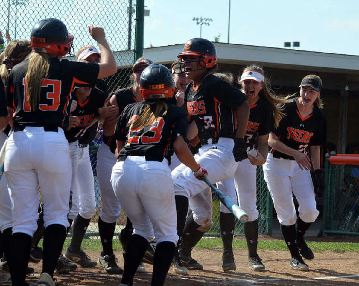 Edwardsville’s Maria Smith, jumping, celebrates a first-inning leadoff home run with her teammates on Friday during the championship game of the Edwardsville Class 4A Regional.