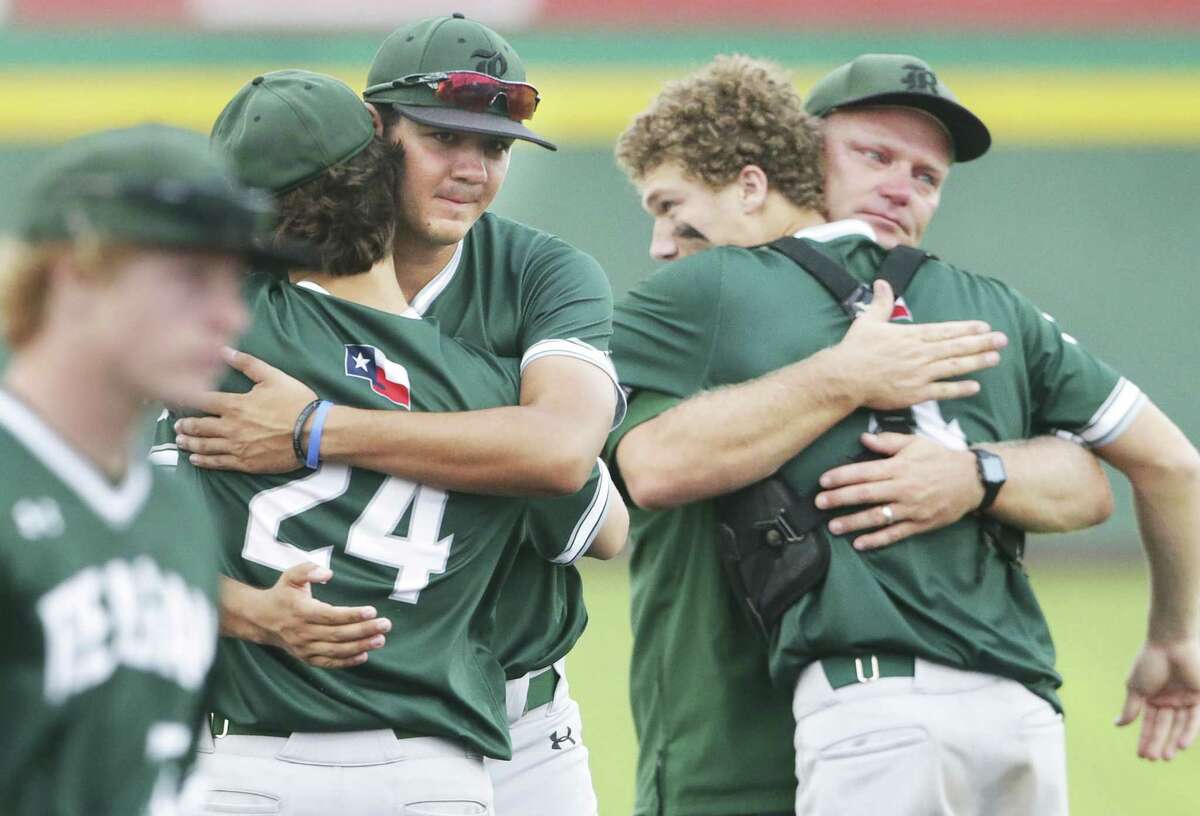 Rattler seniors Cal Martin, center, and Alec Caven, right center, get hugs from teammates and coach Chans Chapman as Reagan loses to Alexander 8-9 in game 2 of the Class 6A Regional Semifinals at Cabaniss Field in Corpus Christi on May 24, 2019.