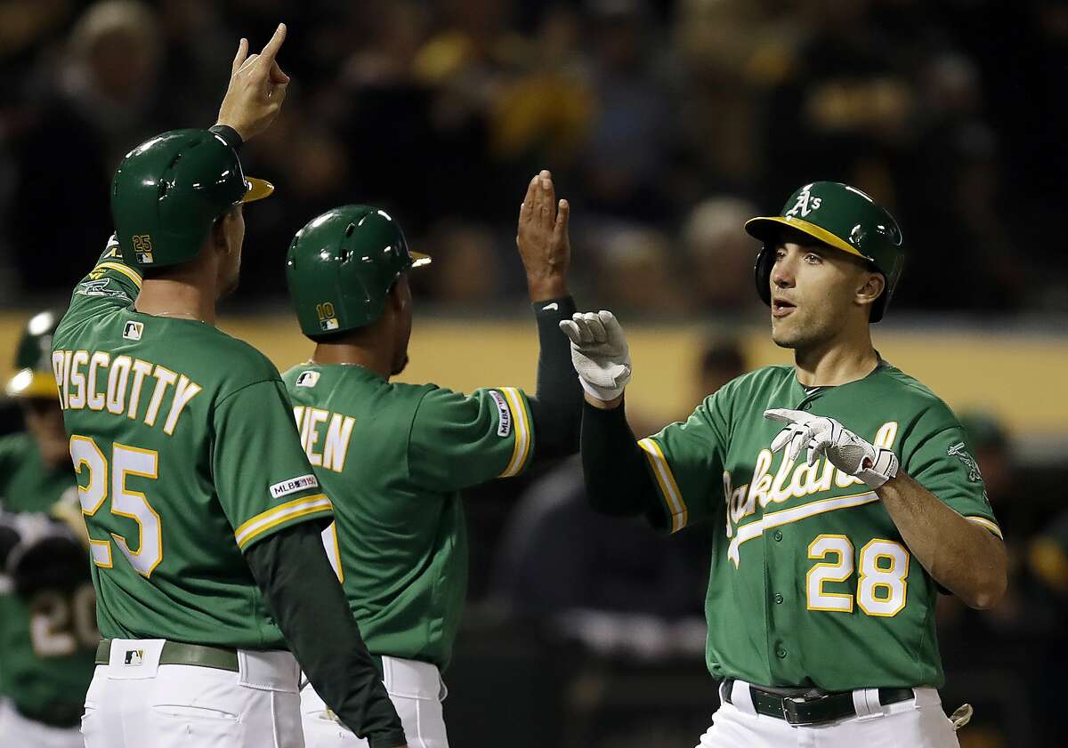 Oakland Athletics' Matt Olson, right, celebrates with Stephen Piscotty (25) and Marcus Semien, center, after hitting a three-run home run off Seattle Mariners' Wade LeBlanc during the fourth inning of a baseball game Friday, May 24, 2019, in Oakland, Calif. (AP Photo/Ben Margot)