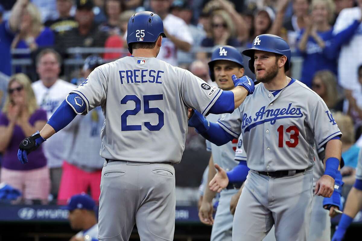 Los Angeles Dodgers' David Freese (25) is greeted by Max Muncy (13) and Corey Seager, center, after hitting a grand slam off Pittsburgh Pirates starting pitcher Michael Feliz during the first inning of a baseball game in Pittsburgh, Friday, May 24, 2019. (AP Photo/Gene J. Puskar)