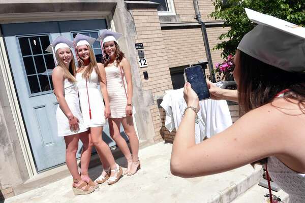 From left, Grace Plunkett, Stephanie Sullivan and Emily Ross have their photograph taken by Catherine Herrick before commencement in the Alumnae Courtyard at Sacred Heart Academy in Hamden on May 25, 2019.