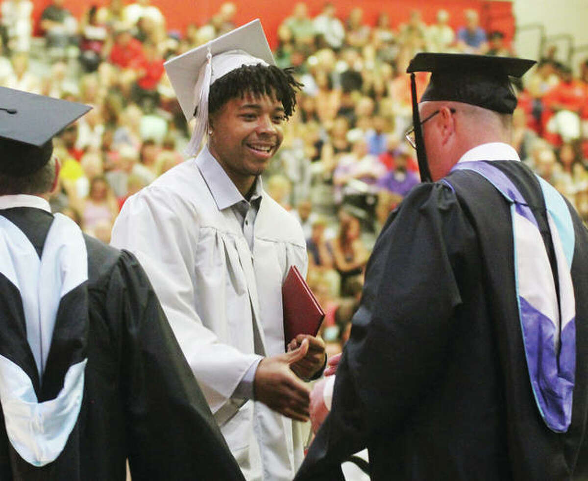 Graduating senior Izeal Terrell shakes Alton High School Principal Mike Bellm’s hand after receiving his diploma during the 150th annual commencement ceremony at Alton High School Friday. There was a standing room only crowd in the AHS gym to watch the approximately 440 seniors graduated.