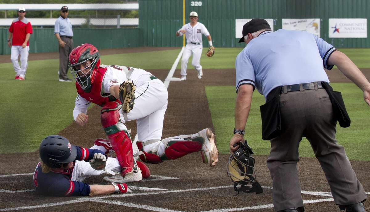 The Woodlands catcher Drew Romo (23) holds the ball up after making the tag on Dawson Goheen #12 of McKinney Boyd out in the fourth inning during a Game 3 of a Region II-6A semifinal high school baseball series at Corsicana High School, Saturday, May 25, 2019, in Corsicana.