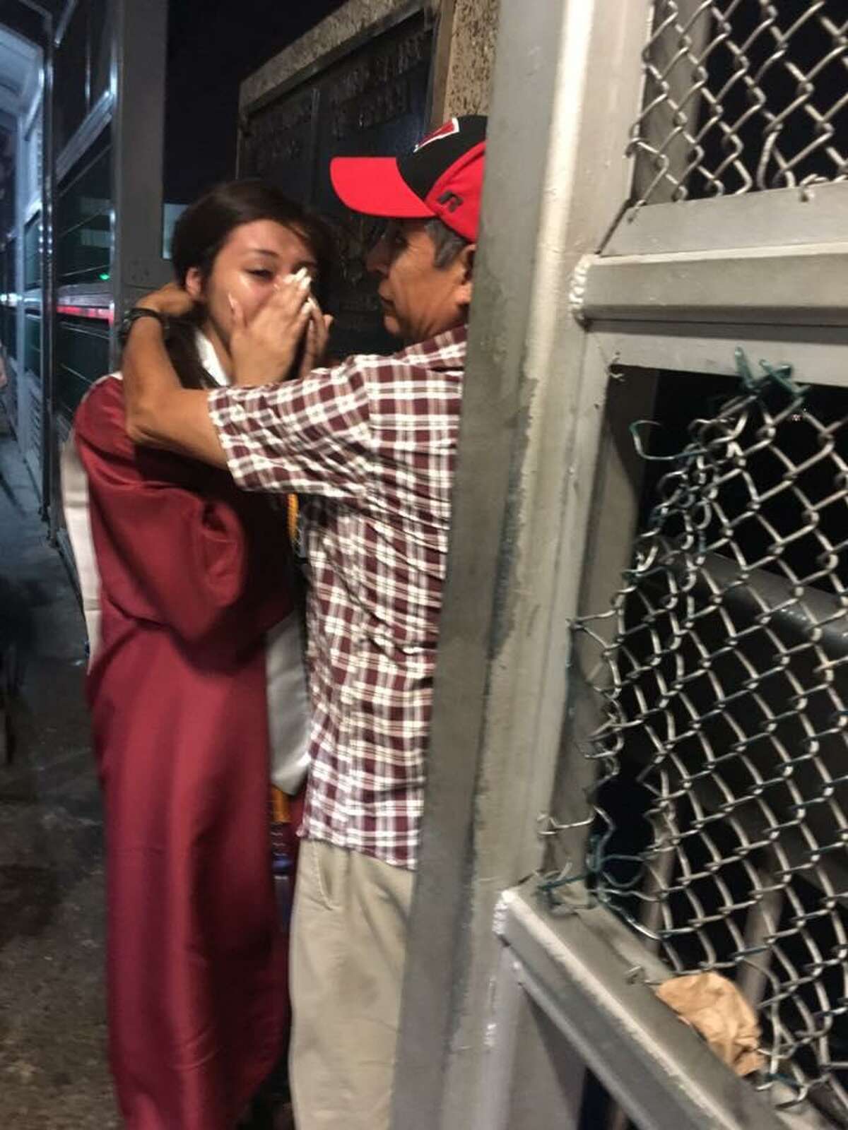 Saraí Ruiz se encuentra con su padre, Esteban Ruiz, a la mitad del puente después de asistir a su graduación de la preparatoria Héctor J. García Early College High School.