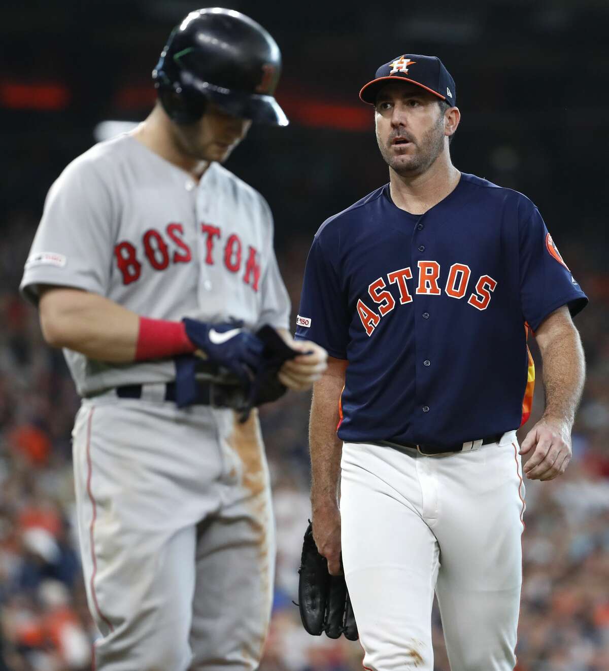 Houston Astros starting pitcher Justin Verlander walks past Boston Red Sox left fielder Andrew Benintendi at the end of the seventh inning of a major league baseball game at Minute Maid Park on Sunday, May 26, 2019, in Houston.