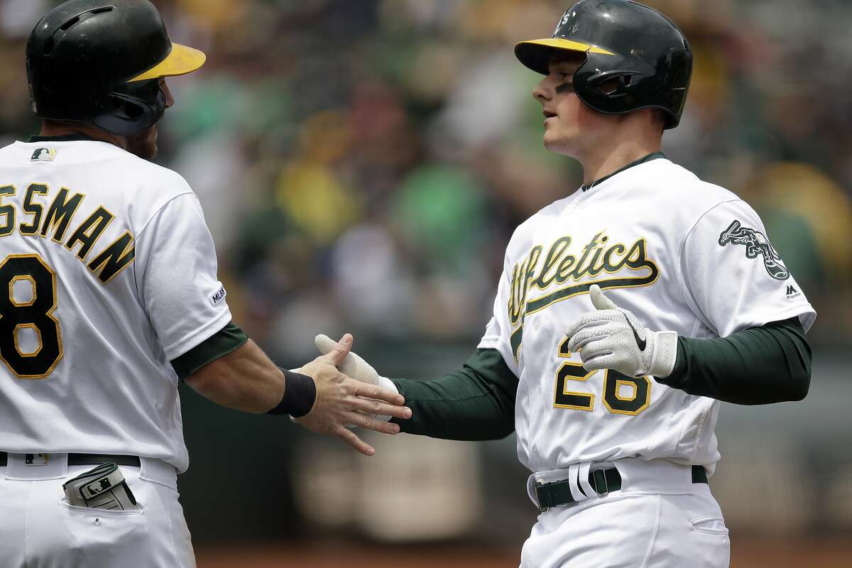 Oakland Athletics' Matt Chapman, right, is congratulated by Robbie Grossman (8) after hitting a two run home run off Seattle Mariners pitcher Mike Leake in the first inning of a baseball game Sunday, May 26, 2019, in Oakland, Calif. (AP Photo/Ben Margot)