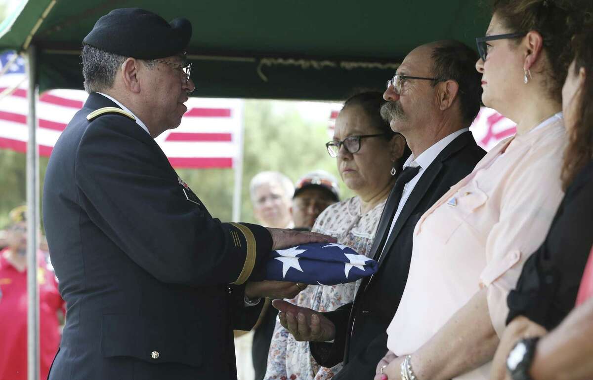 Retired Lt. Gen. Ricardo Sanchez presents a memorial flag to Herschel Marvin Saenz of Pleasanton at a service in Pearsall for his uncle Herschel Riggs, who died in the Korean War.