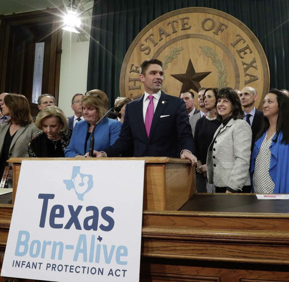 FILE - In this March 7, 2019 file photo, State Rep. Jeff Leach, at podium, stands with fellow lawmakers and guests to talk about the Texas Born-Alive bill, in Austin, Texas. Leach, a Republican lawmaker is blocking a bill that would allow the death penalty for women seeking abortions says local authorities are monitoring his home near Dallas. A Texas sheriff's department said Thursday, April 11, 2019 it had "security concerns" over social media posts targeting Leach, who has come under fire by some conservative activists after blocking a bill that could lead to a woman being charged with homicide if she has an abortion. (AP Photo/Eric Gay, File)