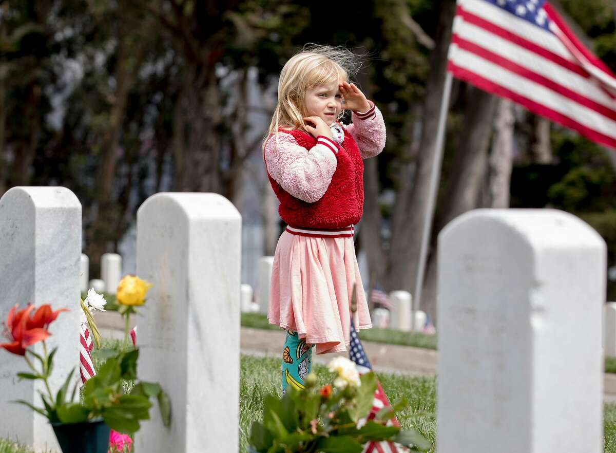 Evey Hillesheim, 6, of Pleasant Hill salutes a passing car carrying veterans during the annual Memorial Day observance held at the Presidio Cemetery in San Francisco, Calif. Monday, May 27, 2019.