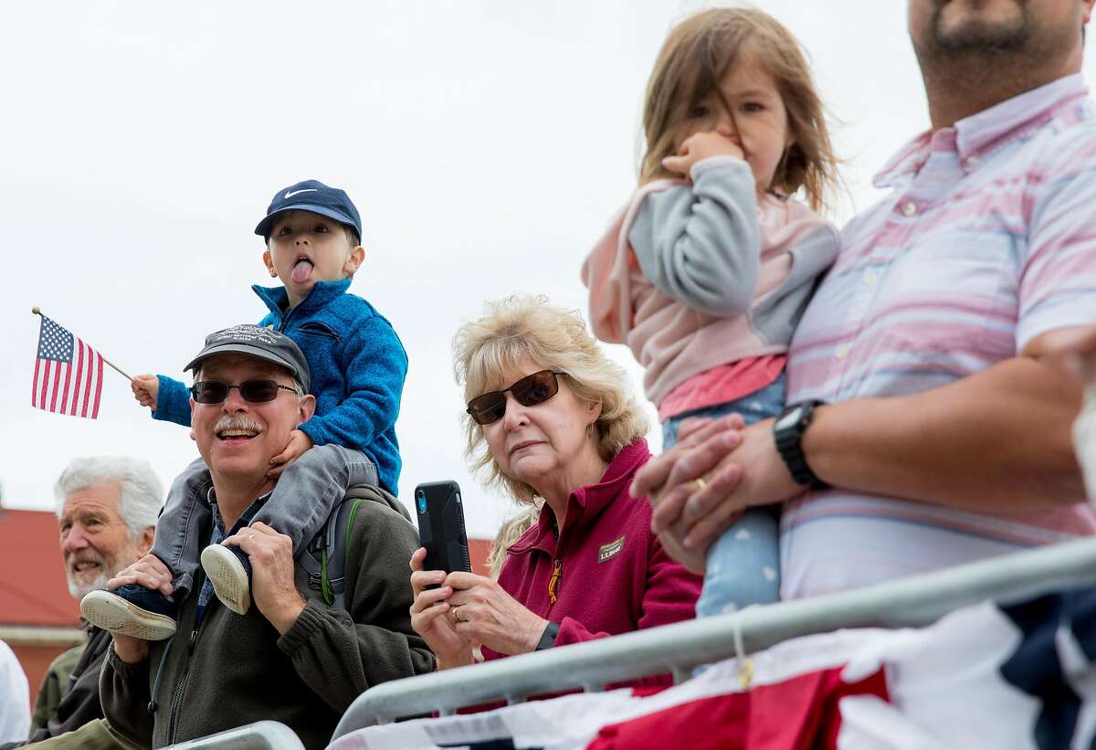 Spectators watch from the sidelines as a parade moves through the Presidio during the annual Memorial Day observance held at the Presidio Cemetery in San Francisco, Calif. Monday, May 27, 2019.