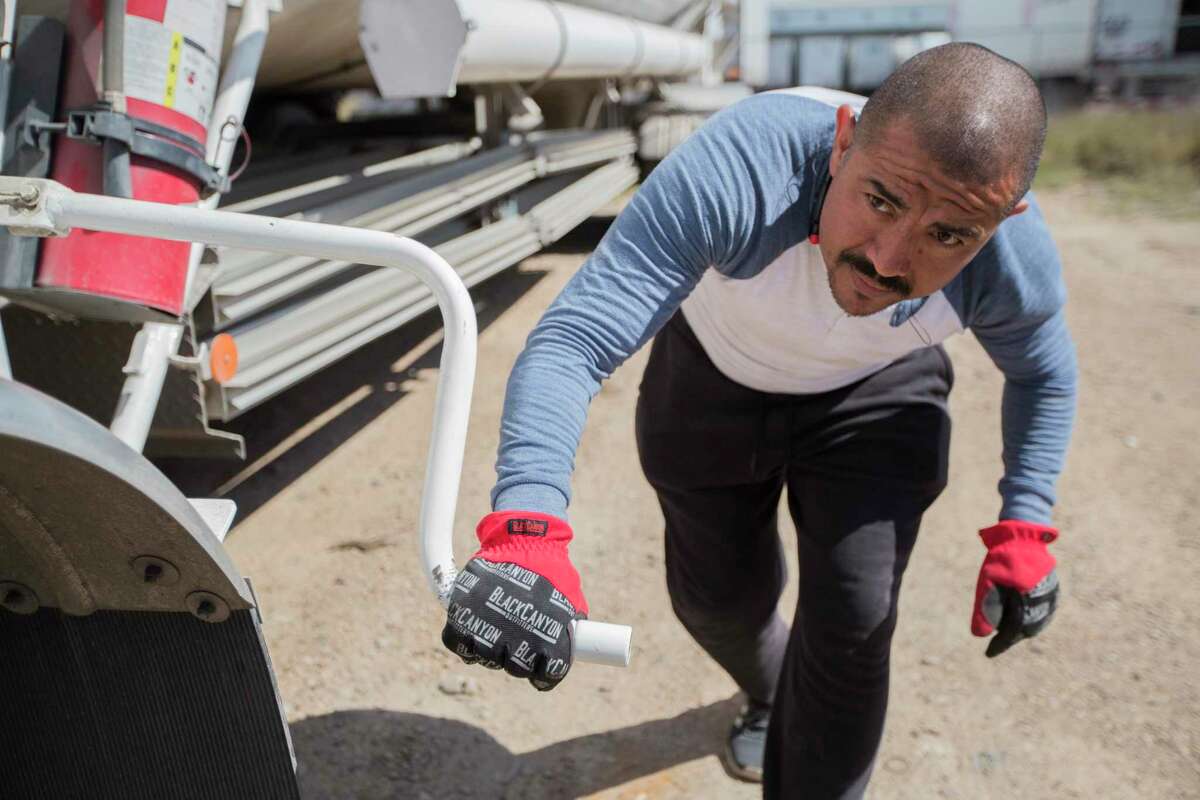 Francisco Muñoz, a trucker attaches a tank with liquefied natural gas to later transport into a truck yard in Mexico on Tuesday, April 2, 2019, in Laredo.