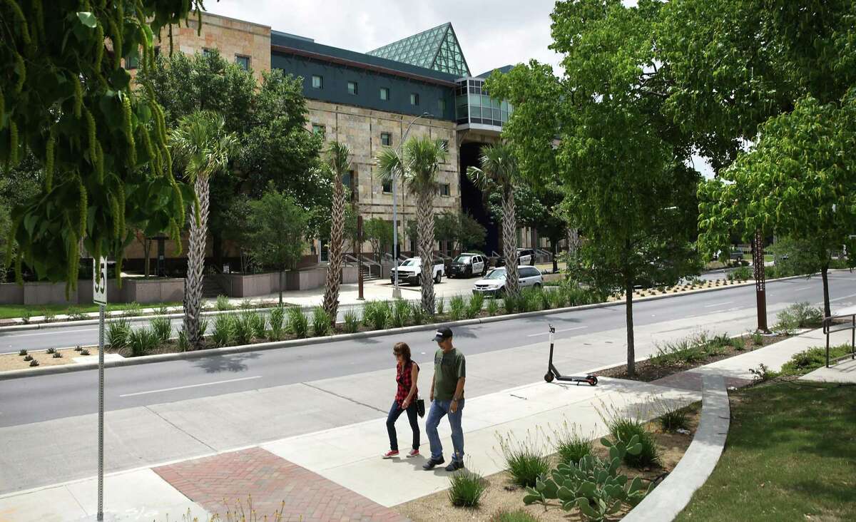 A couple walks past cacti, palms and other native plants on Frio Street at the UTSA downtown campus.