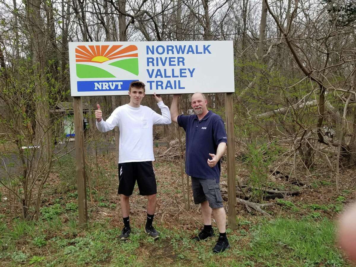 Boy Scout Colton Lovell, pictured with his father Mike, installed signage for the Norwalk River Valley Trail at Wolfpit Road and Route 7.
