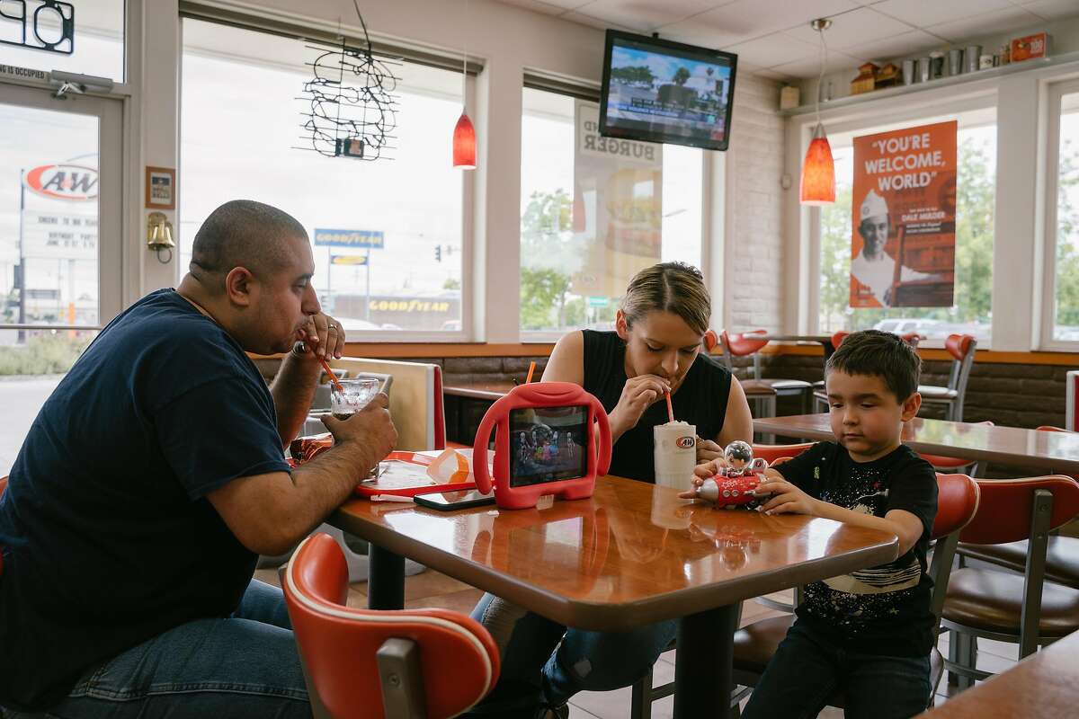 (Left) Tom and Amanda Becerra eat lunch with their son Oliver, 4, at A&W in Lodi, Calif., on Monday, May 27, 2019. The A&W franchise originally founded in Lodi, will be celebrating its 100th anniversary in June.