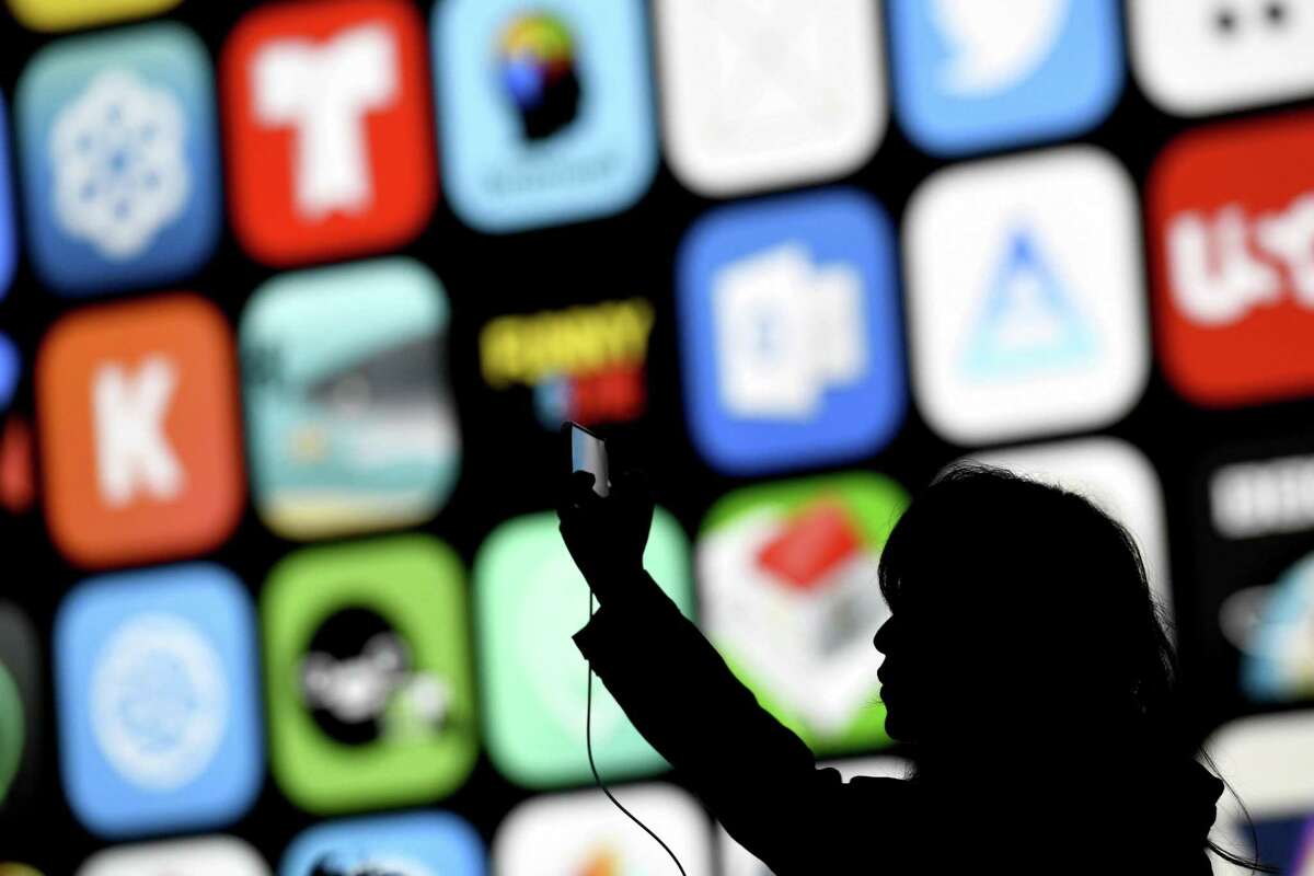 The silhouette of an attendee is seen taking a photograph with a mobile device before the start of the Apple Worldwide Developers Conference (WWDC) in San Jose, California, U.S., on Monday, June 4, 2018. Photographer: David Paul Morris/Bloomberg