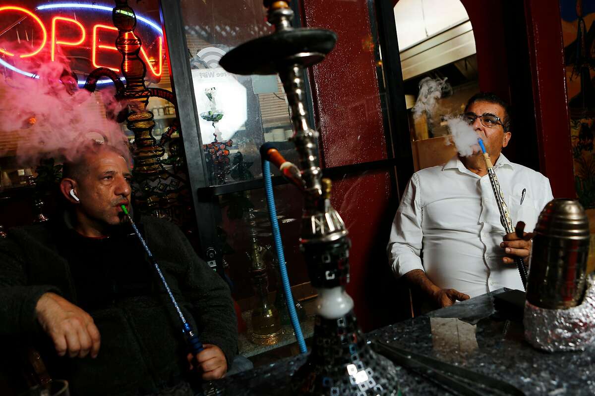 From left: Khaled Shehadeh and Adnan Abu Sharkh smoke hookah at Pride of the Mediterranean on Tuesday, Nov. 27, 2018, in San Francisco, Calif. Sharkh is the owner of the hookah lounge and restaurant, which is located at 1761 Fillmore St.