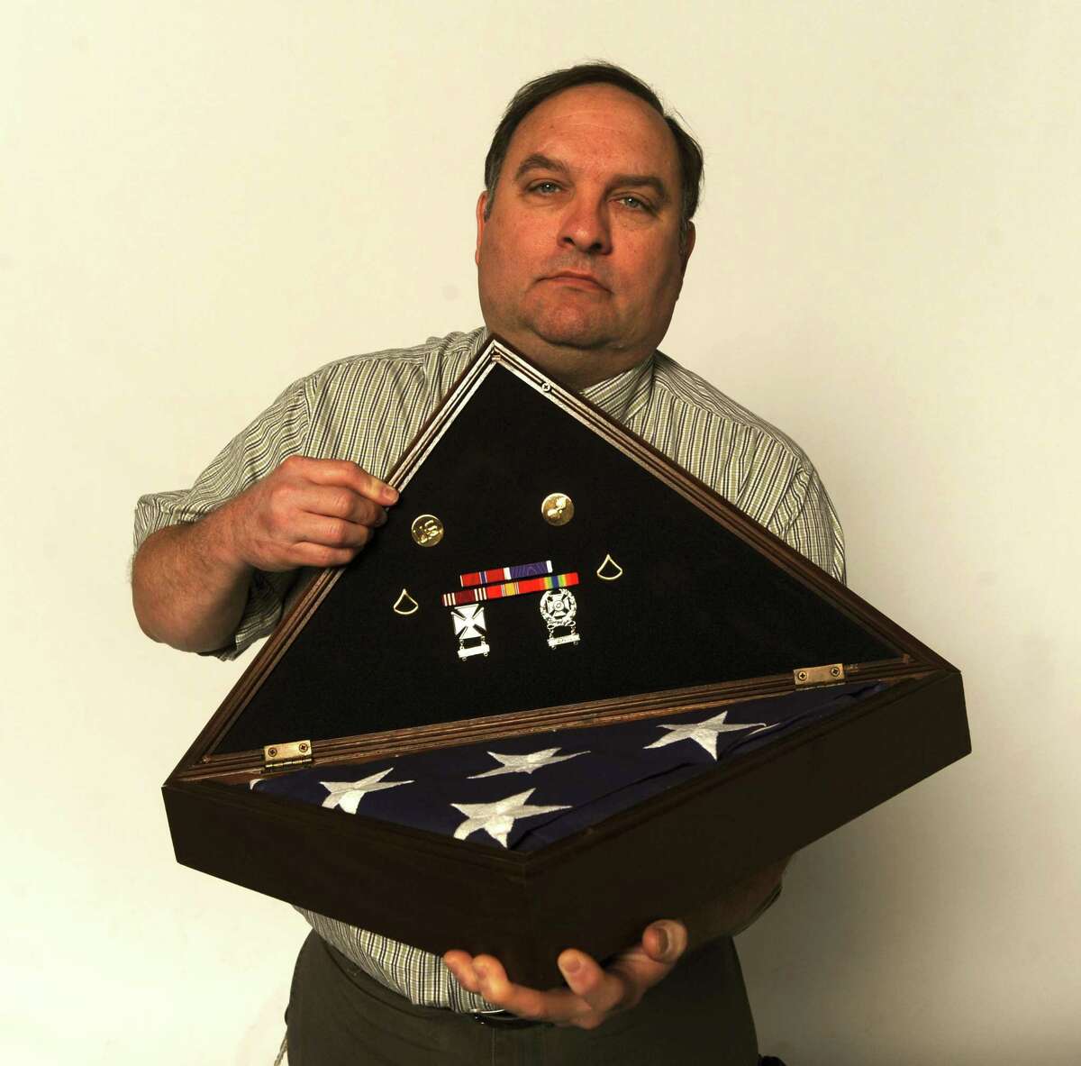 Patrick Miller displays decorations and the flag that draped the casket of his son, Army Pfc. Anthony Scott Miller, who died at age 19 on April 7, 2003, the first San Antonio native to die in the Iraq War.