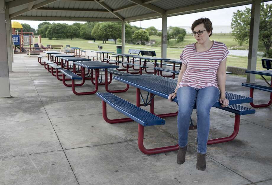 Anne Marie Miller sits on a picnic table at Greenbriar Park in Fort Worth, where she says Mark Aderholt would take her to make out when she was a teenager. Photo: Jon Shapley/Staff Photographer