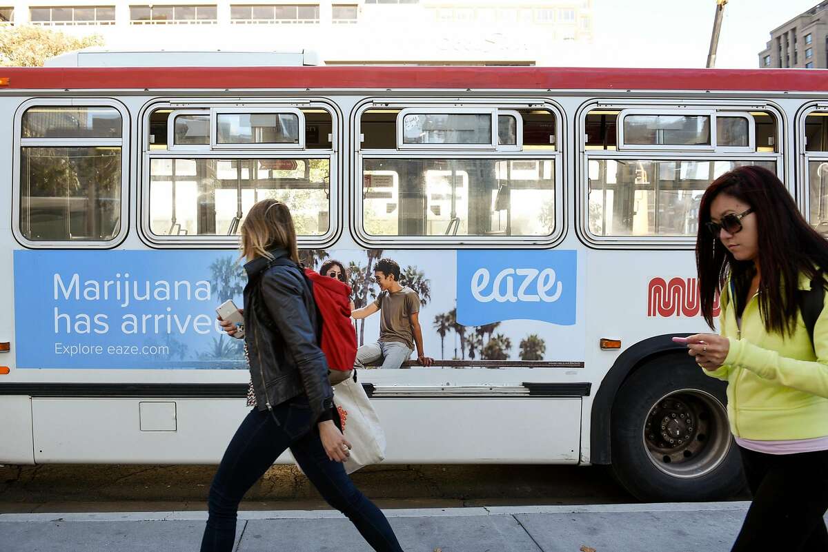 Pedestrians walk past an advertisement on the side of a MUNI bus for marijuana delivery service Eaze in downtown San Francisco, CA, on Friday November 17, 2017.