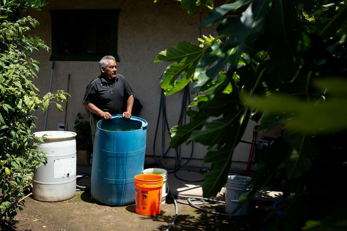 A portrait of Jose Hernandez at the San Jerardo Cooperative on Friday, May 24, 2019, in Salinas, Calif. Hernandez says his new water bill is expensive after the area implemented a new water system. Hernandez fears the water is still undrinkable and also relies on rain water and reusing the water from his wash-and-dry (blue bucket) to use on his garden and reduce his bill.