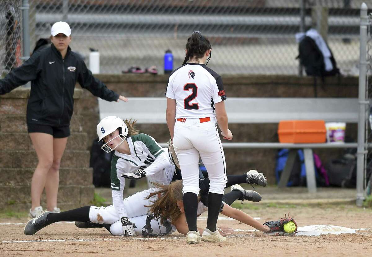 Stamford's Jordan Rossi tags the base for the out in a collision with New Milford's Sarah Mickelson during a Class LL state tournament game on Wednesday. Stamford won, 10-0.
