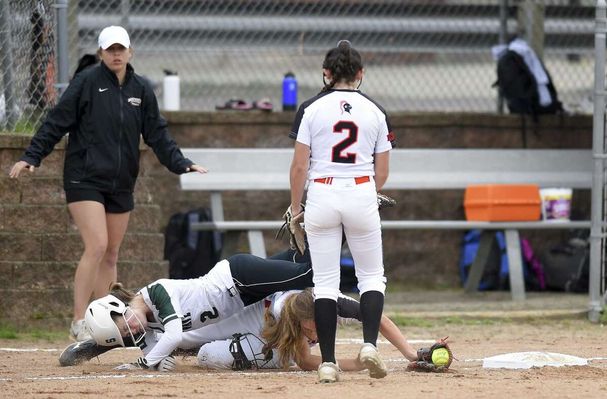 Stamford's Jordan Rossi tags the base for the out in a collision with New Milford's Sarah Mickelson in a Class LL state tournament game on Wednesday. Stamford won, 10-0.