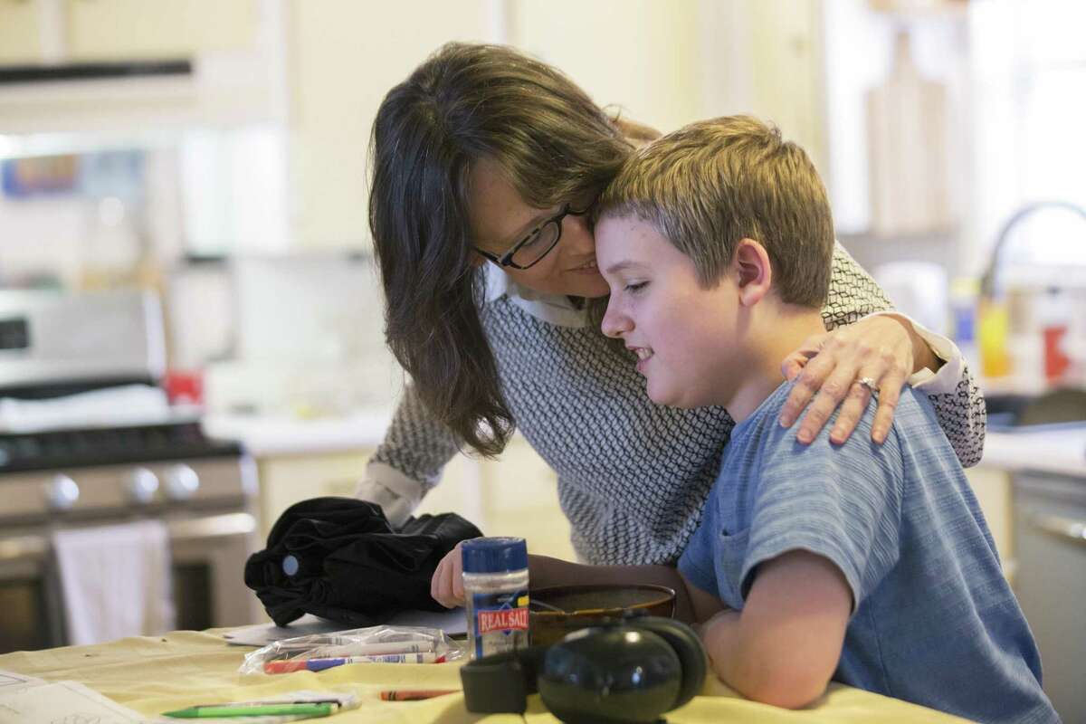 Bonnie Jensen kisses and says goodbye to her son Micah Jensen, 12, before leaving to meet with other mothers with special needs children who are excluded from the Texas' Compassionate Use Program in February 2018. Texas is close to passing a law that would legalize certain marijuana products, cannibinoid oil, with 0.3 percent or less of the pyschoactive ingredient THC; other bills that would expand the state’s medical marijuana program, which allows doctors to prescribe up to 0.5 percent of those products, meanwhile, have stalled. ( Marie D. De Jesus / Houston Chronicle )