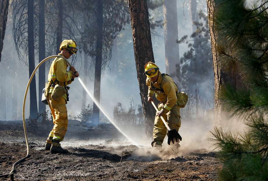 Firefighters douse hot spots along highway 120 near Groveland, Calif. on Wednesday August 28, 2013, during the Rim Fire in the Stanislaus National Forest. Photo: Michael Macor / The Chronicle 2013