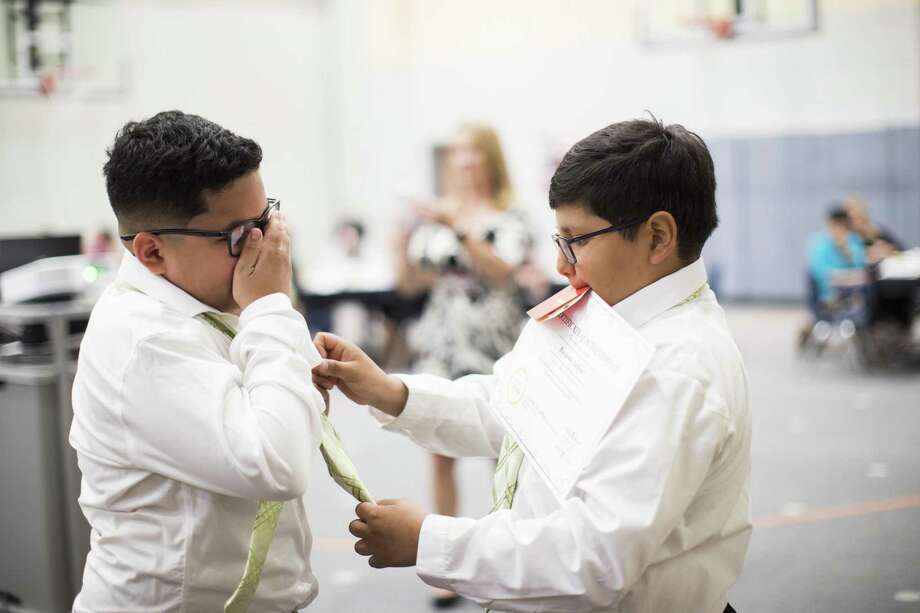 Ricardo Ardon, right, helps Charles Cerda, left, with his new tie on Thursday, May 23, 2019, in Houston, during a "Pearls For Girls" and "Ties For Guys" event on Thursday, May 23, 2019, in Houston. The event was to celebrate the student members who completed the programs "Pearls For Girls" and "Ties For Guys." Photo: Marie D. De Jesús,  Houston Chronicle / Staff Photographer / © 2019 Houston Chronicle