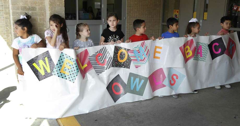 Frazier Elementary School students hold a sign up for graduating seniors from Dobie High School who attended Frazier as they returned in their granduation gowns, to interact with the Frazier children, Friday, May 24, 2019. Photo: Karen Warren,  Houston Chronicle / Staff Photographer / © 2019 Houston Chronicle