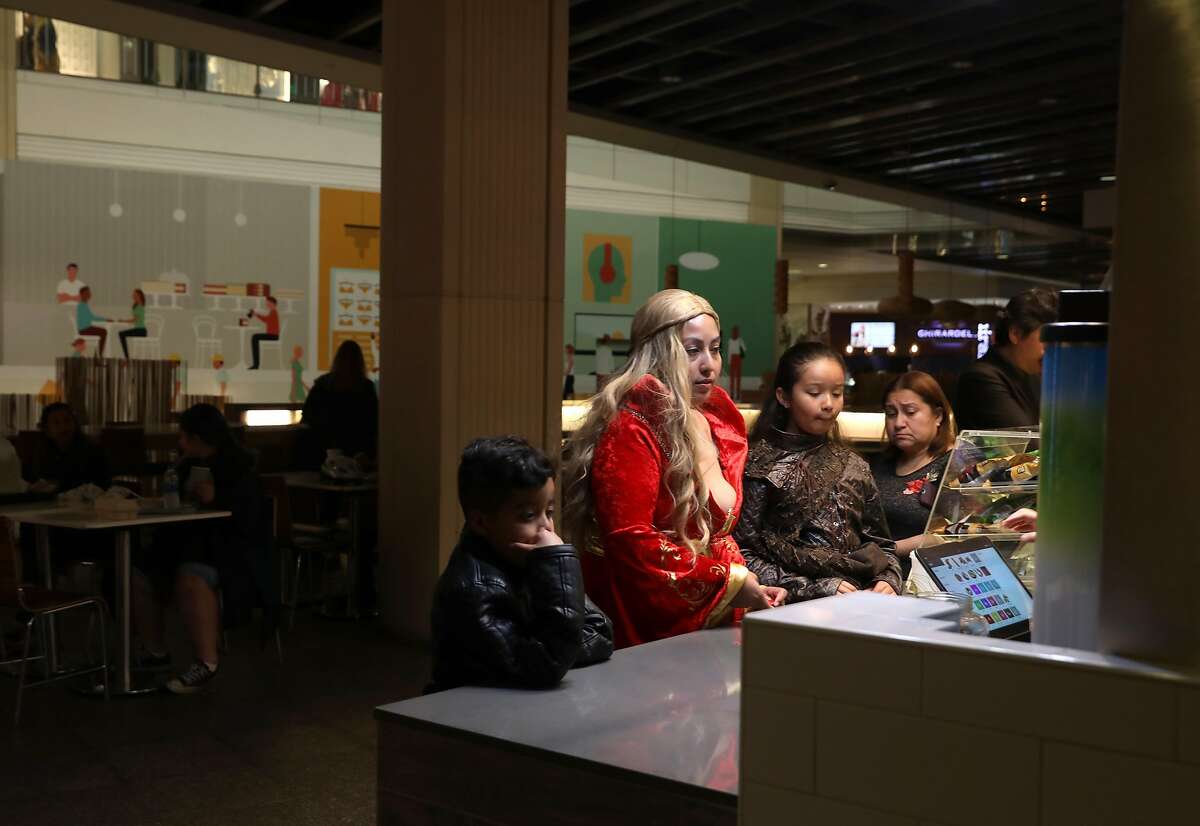 Christina Sanchez (wearing red) from Union City buys lunch from Fire of Brazil Churrascaria Express with her nephew Kymani and niece Kaliyah during a power outage at the Bloomingdale's part of the food court at Westfield Mall on Thursday, May 30, 2019, in San Francisco, Calif. They were taking a break from a Game of Thrones exhibit.