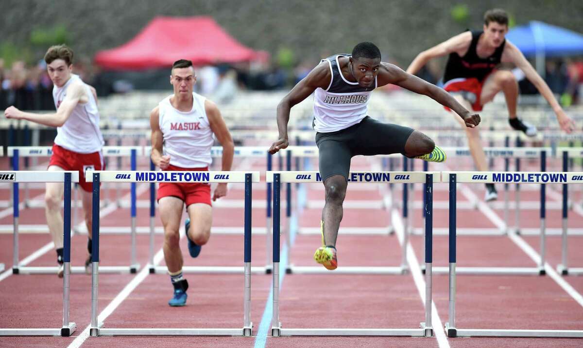Hillhouse’s Deshaune Poole, center, runs to a first-place finish in the 110 meter hurdles at the CIAC Class MM outdoor track championship at Middletown High on Wednesday.