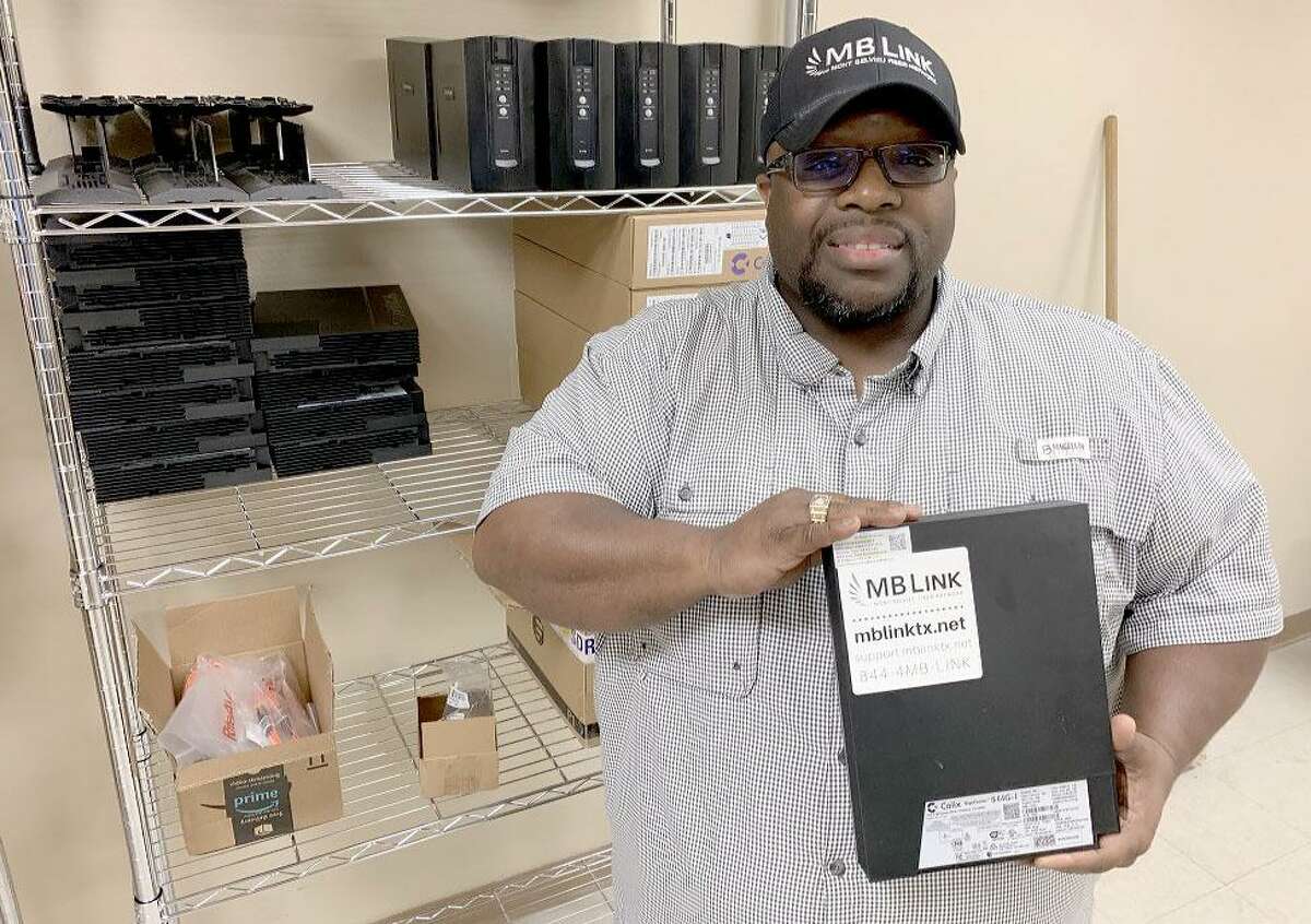 Dwight Thomas, Mont Belvieu’s director of broadband and IT systems, holds one of the fiber optic modems that are placed in MB Link customers’ homes.