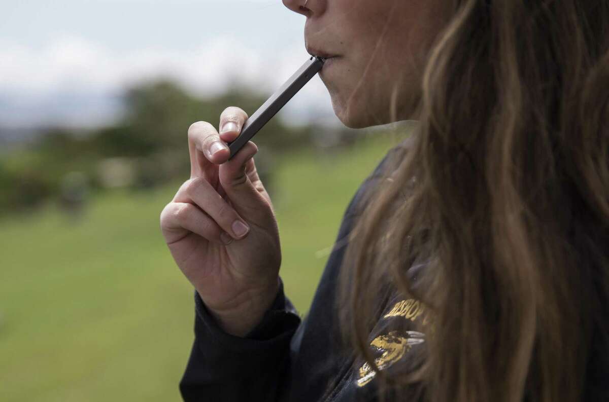 A high school student smokes from a Juul e-cigarette at Mountain View Cemetery in Oakland, Calif. Wednesday, May 16, 2018.