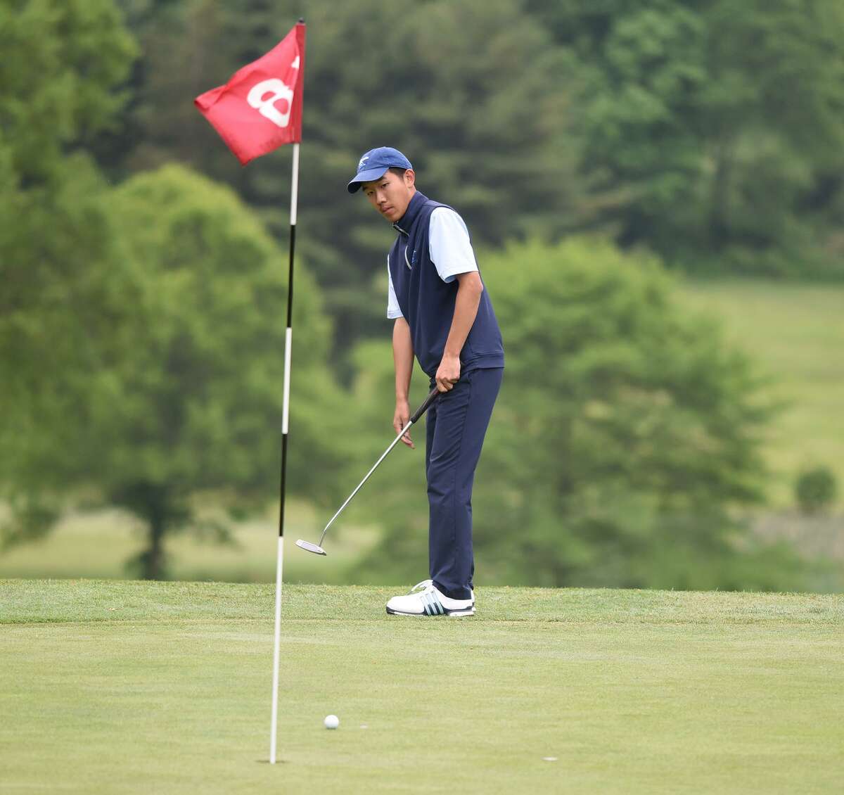 Darien’s Alex Gu putts on the 18th green during the FCIAC boys golf championship at Fairchild Wheeler Golf Course in Fairfield on Thursday.