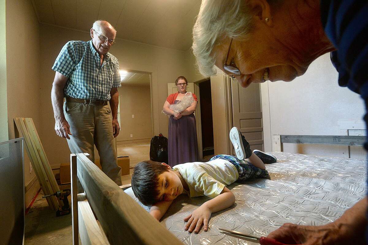 Jack and Charlotte Seely with the newly-formed local chapter of the national non-profit group Sleep in Heavenly Peace and Cristen Lewis (back center) look on as Lewis' son Noah Johnson rests atop hismattress as it inflates at the Lewis' soon-to-be home in Orange. Lewis and her family of five are moving to Orange from their small apartment in Sour Lake and were in need of assistance with getting beds for her two older children, Noah and Kathyleen Edwards, 10 (not pictured). Photo taken Tuesday, May 14, 2019 Kim Brent/The Enterprise