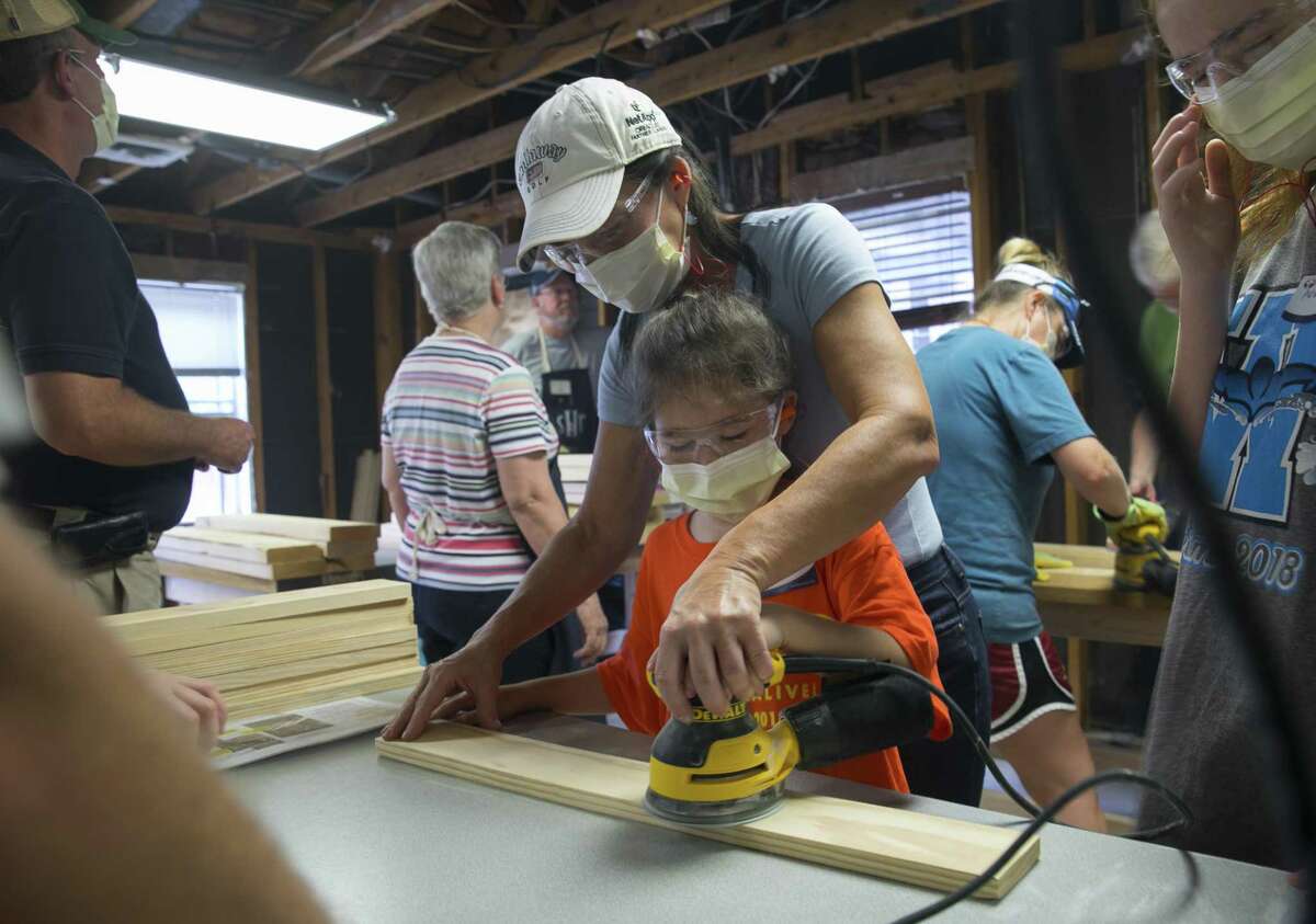 Lori McCray assists her 8-year-old daughter Sloane sand wooden slats during the second bunk bed build of the Northwest Houston Chapter of the Sleep in Heavenly Peace organization on Saturday, Sept. 8, 2018, in Cypress.