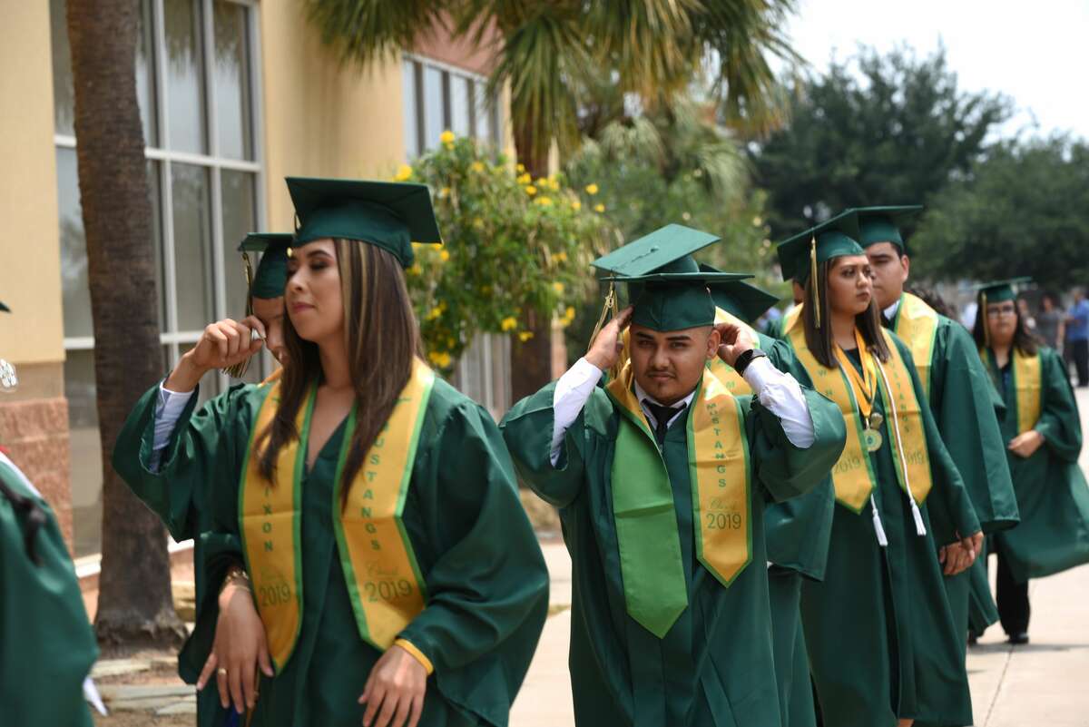 Students walk out of buses and walk towards the arena with their classmates during Nixon High School's graduation at Sames Auto Arena, Thursday, May 30, 2019.