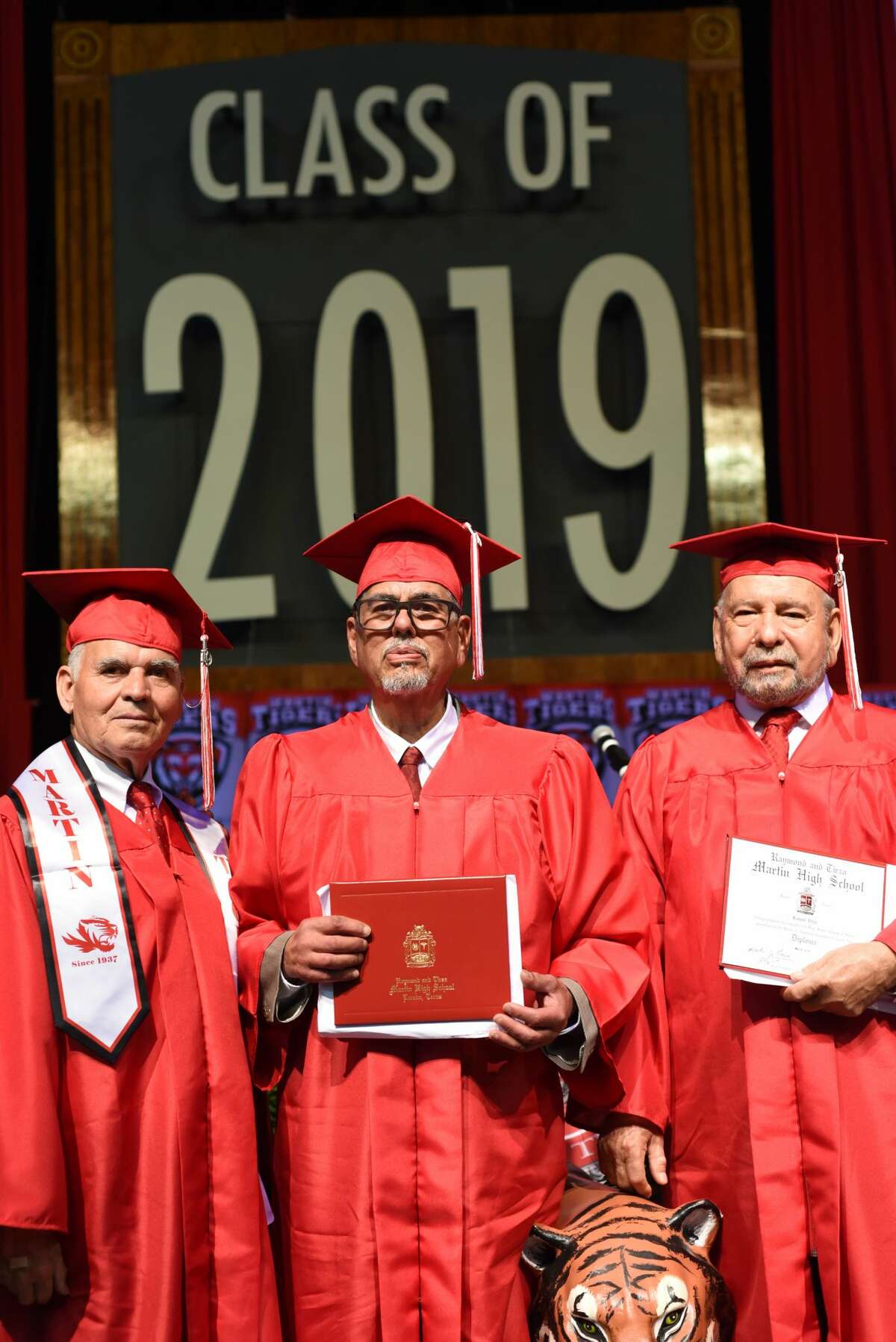 U.S. Veterans Miguel Romo, Dogberto Carmona and Roque Vela Sr. stand with their High School degrees during Martin High School's graduation at Sames Auto Arena, Thursday, May 30, 2019.
