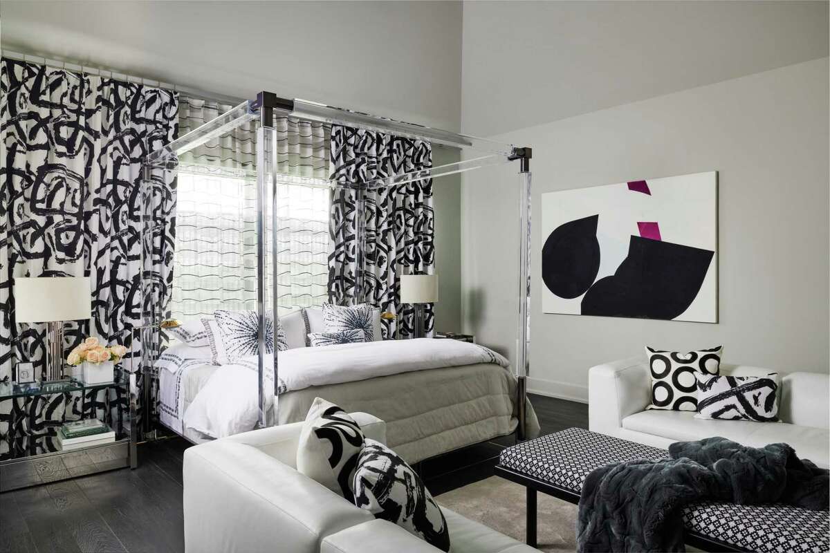 The master bedroom in a graphic black and white, has a Charles Hollis Jones-designed acrylic bed once owned by Sylvester Stallone.